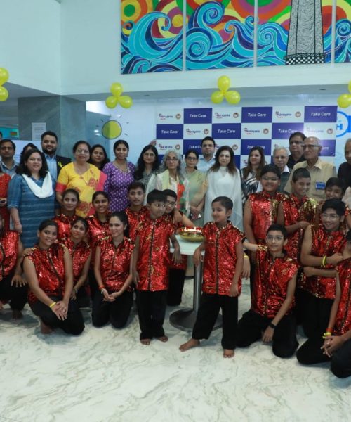 Group photo from a children’s event with colorful decorations in Mumbai.